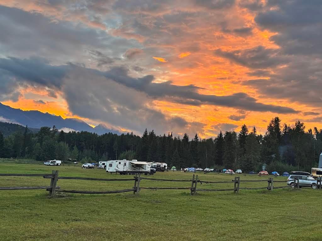 Campers below the mountains at sunset at Golden Riverfront Campground